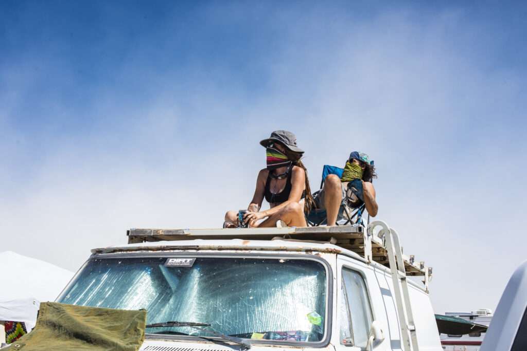 A couple sitting on top of a van