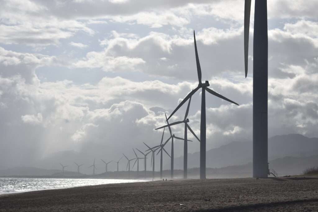 Windmills on seashore under white clouds